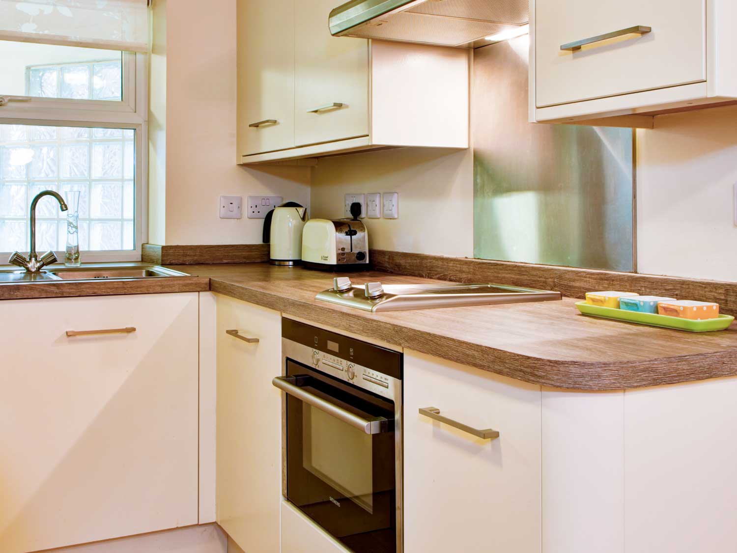 A smart kitchen with solid wood work surfaces, integrated appliances and modern, white kitchen units